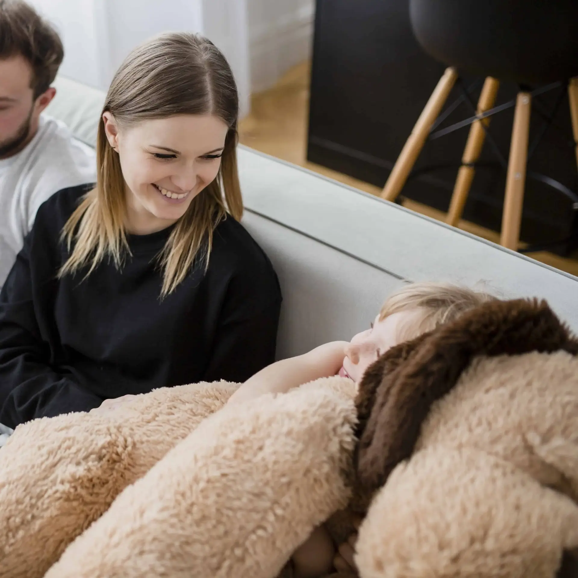 Niña abrazando a un peluche junto a sus padres